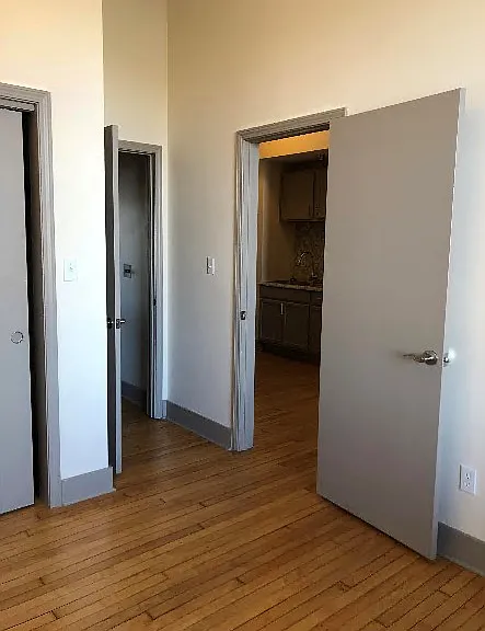 view from bedroom toward kitchen sink. closet doors on the left.