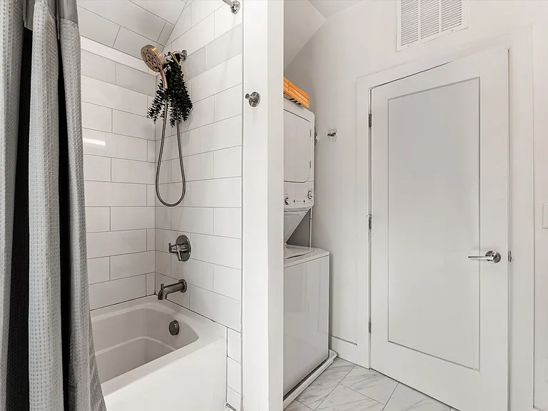 Studio bathroom with modern finishes and a washer & dryer.