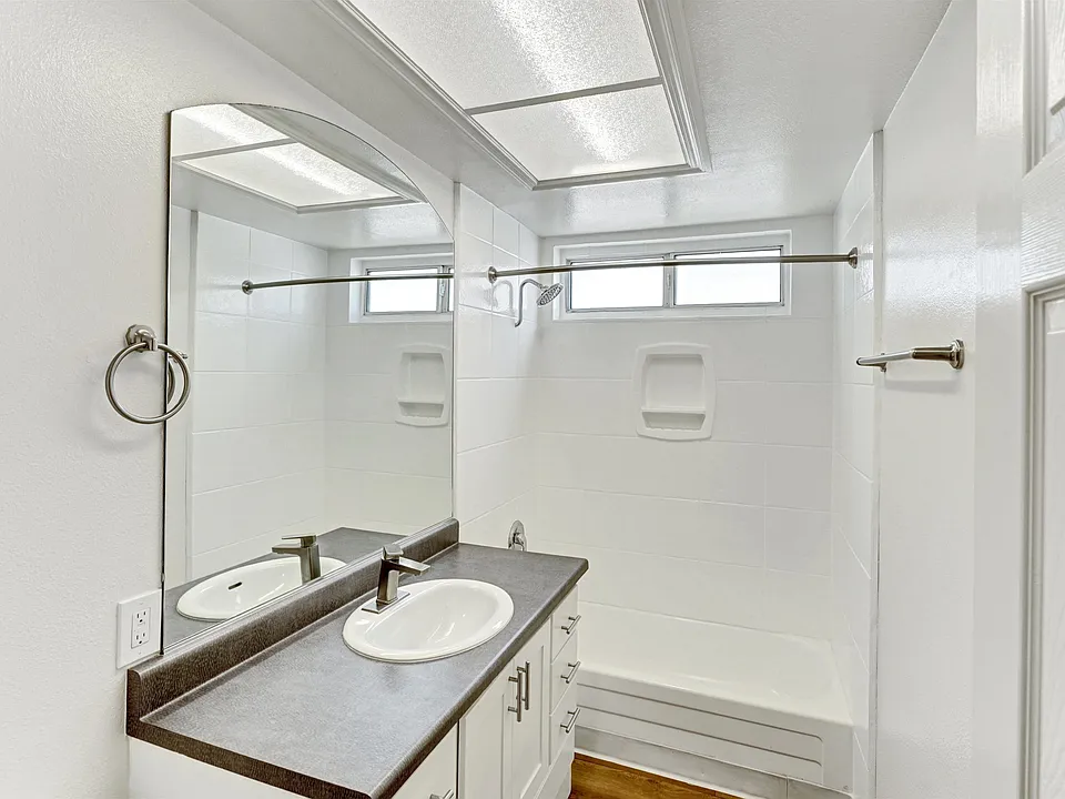 A bathroom with a sink vanity and a mirror above it.