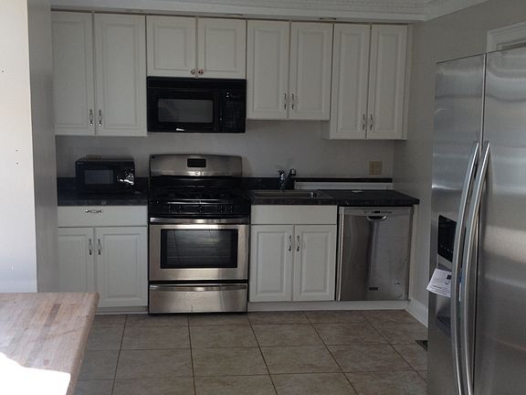 Kitchen with new appliances and tile floor