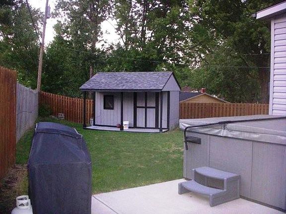 Privacy fenced rear yard with storage barn.