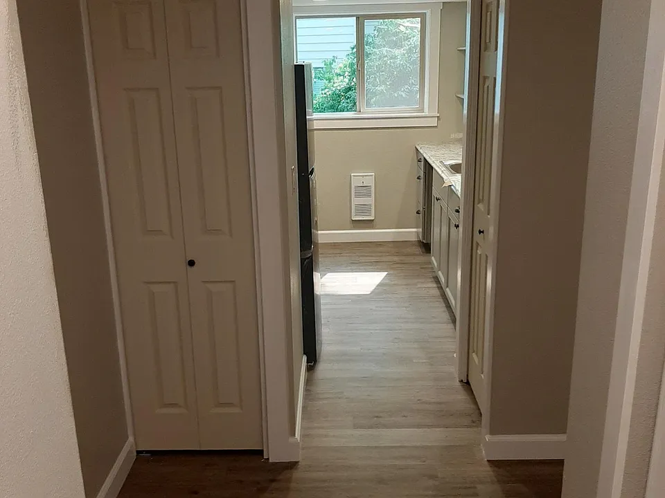 From the front door, looking into the kitchen. Look at those beautiful new floors, luxury vinyl plank that is quiet, soft underfoot, and insulating!