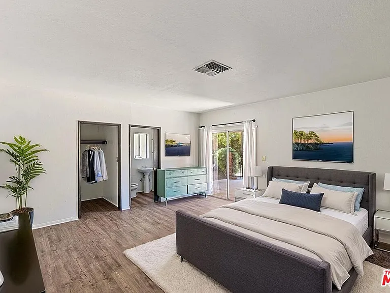 Master bedroom showing walk in closet (L) and Bathroom (R). Exit door to back yard.
