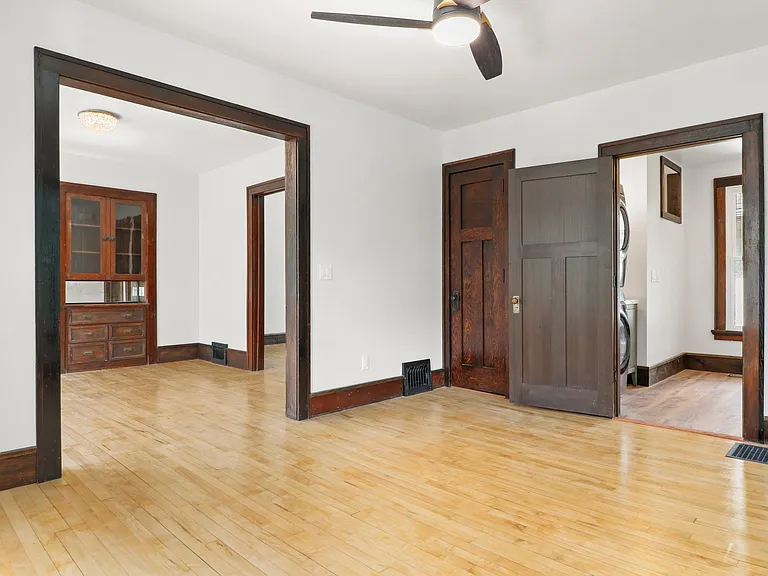 This is the top floor den and dining room and open door to a large bathroom. Behind the closed door, there is a stackable washer and dryer! Look at the lovely hardwoods!