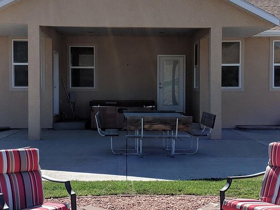 Back of home with patio and fire pit area.