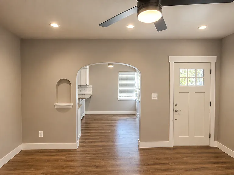 Living area with updated flooring and an open flow to the kitchen.