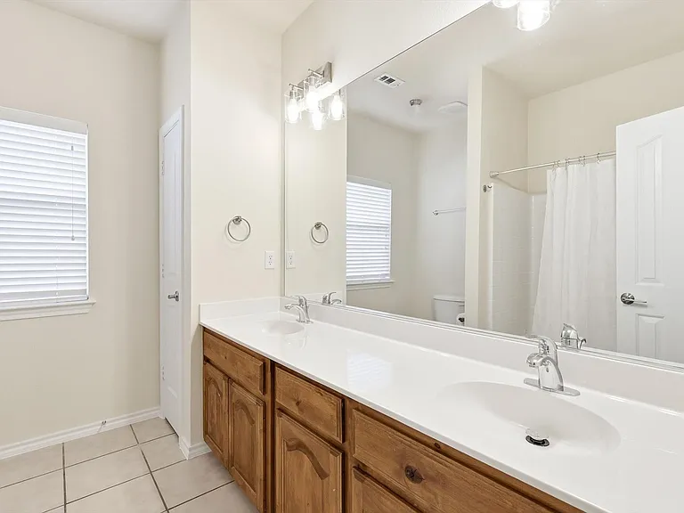 And a close up of the double vanities with recently installed attractive lighting for your convvenience as you rush to get out.