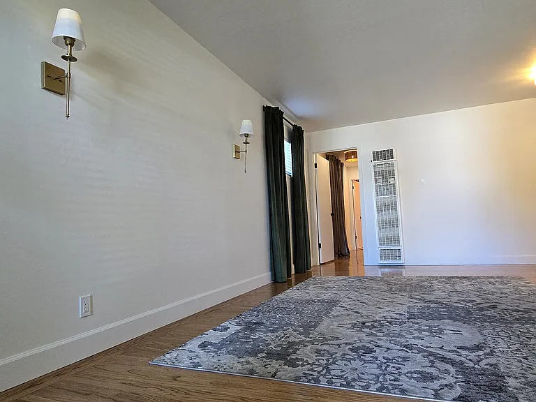 Move-in ready living room with upgraded lighting and window coverings.