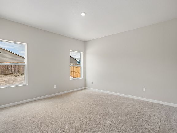 The master bedroom is spacious with two large windows.