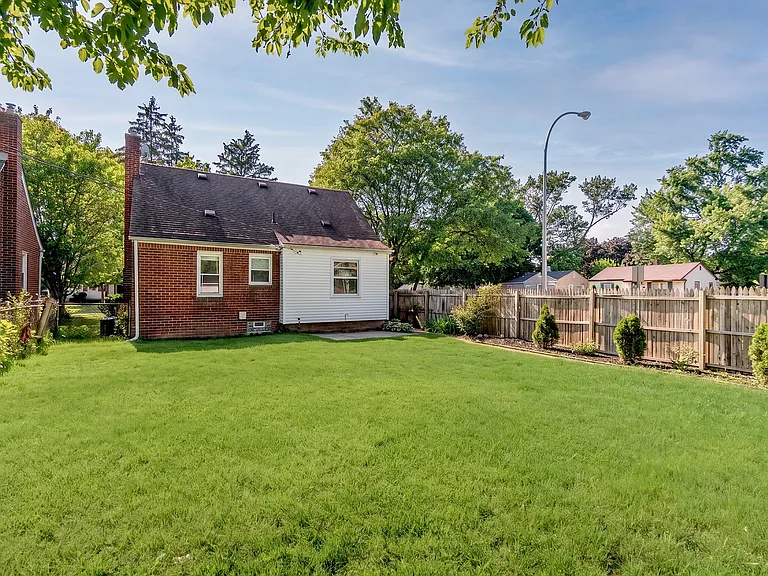Alternate view from the detached garage showcasing the expansive backyard and rear exterior of this beautiful Royal Oak home.