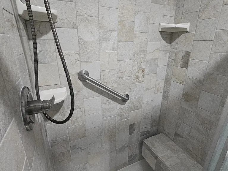 Walk in tile shower with built in bench seating.