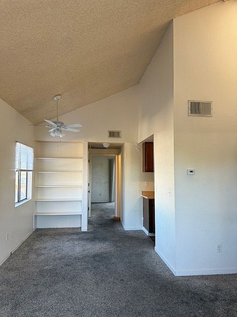Dining area and entrance to galley kitchen. Note built-in book and curio shelves