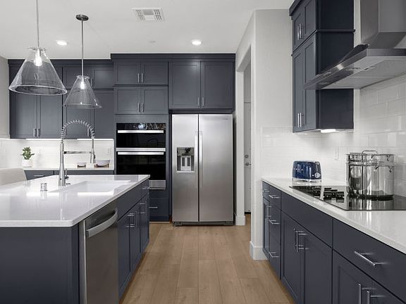 Kitchen with blue slab cabinetry in a chef s appliance package