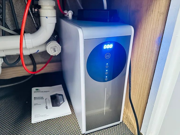 Tankless reverse osmosis water filtration system under sink in kitchen.