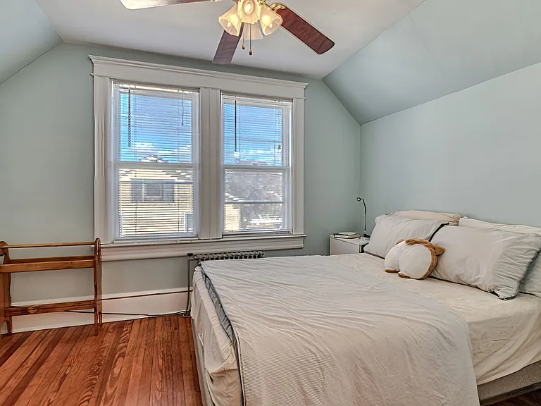 North facing back bedroom. Full size bed, 2 bedside tables, lovely vintage dresser, easy chair, ceiling fan, closet