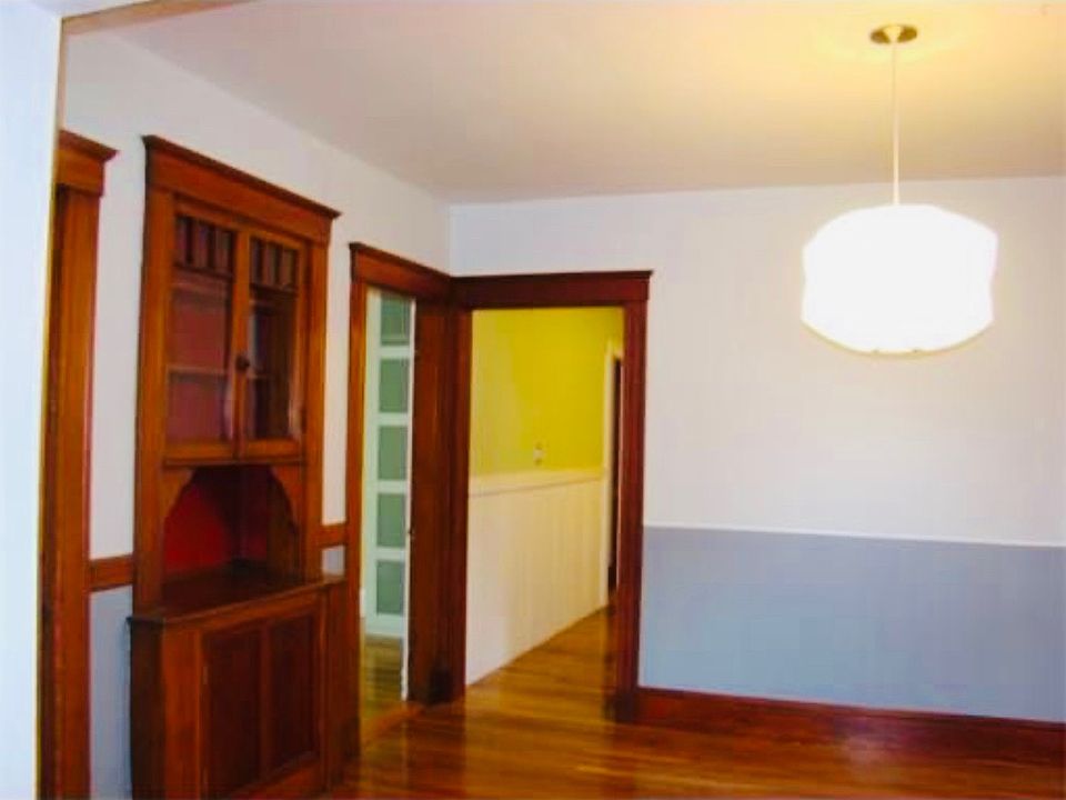 Dining Room looking into kitchen. Note the China cabinet and hardwood floors.