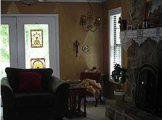 Cozy den with a woodburning fireplace and french doors to a large deck.