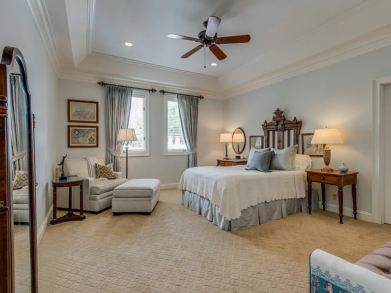 Primary bedroom with ceiling fan, walk in closet, closet system