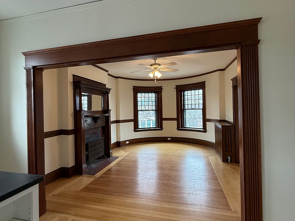 Large dining room with wood burning fireplace and grand windows.