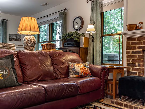 A very comfortable living room with windows looking out to the trees.