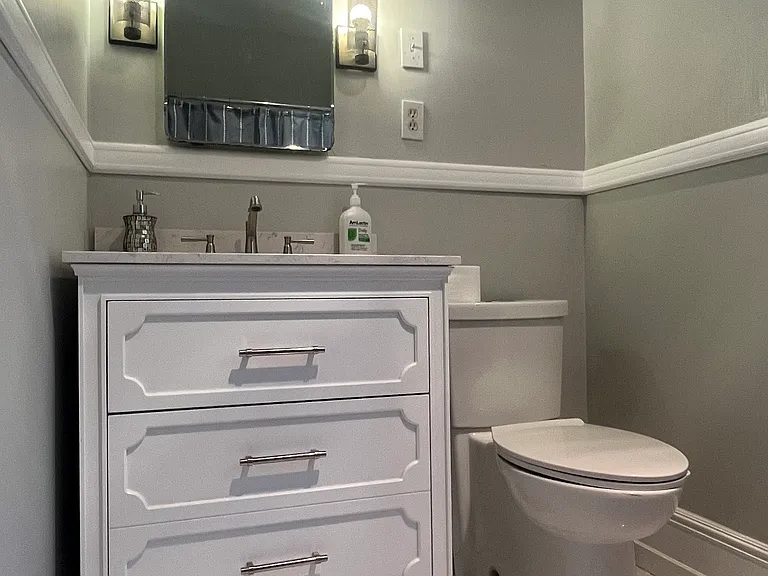 Full bathroom - marble floors, stone vanity, and custom chair rail