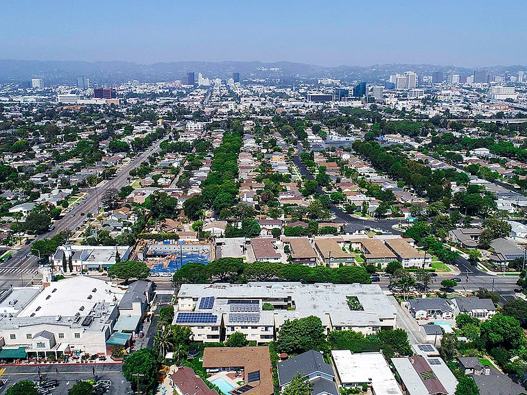 Aerial drone view of National Apartments depicting roof-mounted solar panels and adjacency to Whole Foods Market.