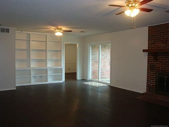 Another view of living room from entrance hall.  Features fireplace, built in bookcases & slider to back yard.