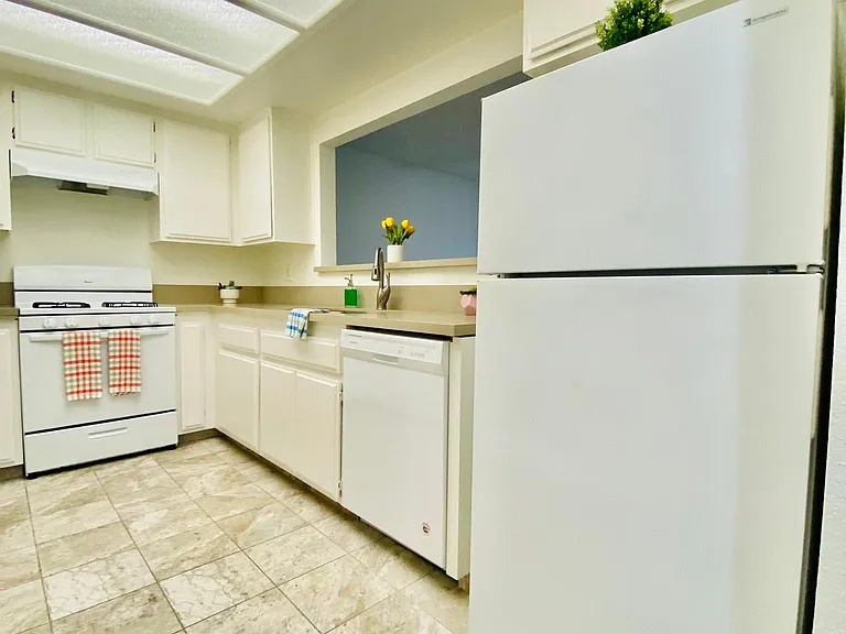 Kitchen with Gas stove-oven, dishwasher and refrigerator.