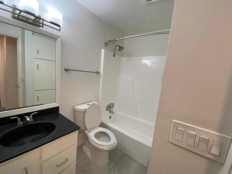 Hall Bath 2 with linen storage and a tub/shower combo