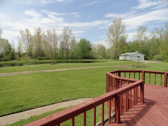 The spacious deck with a southern exposure overlooks the approximate 1/2 acre pond and large yard which borders a several acre wooded area!
