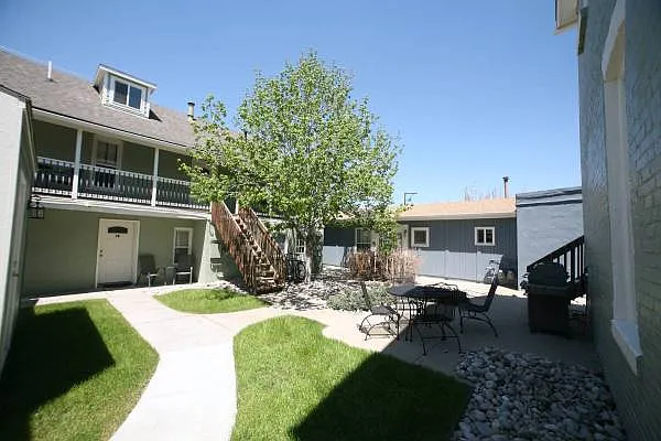 Alternate view of the gated courtyard featuring a community patio set and BBQ grill, perfect for relaxing on a Colorado summer evening