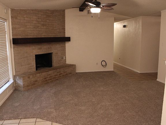 Livingroom view from dining room. Brick fireplace, attractive wood center beam and fireplace mantle, new carpet and fresh paint.
