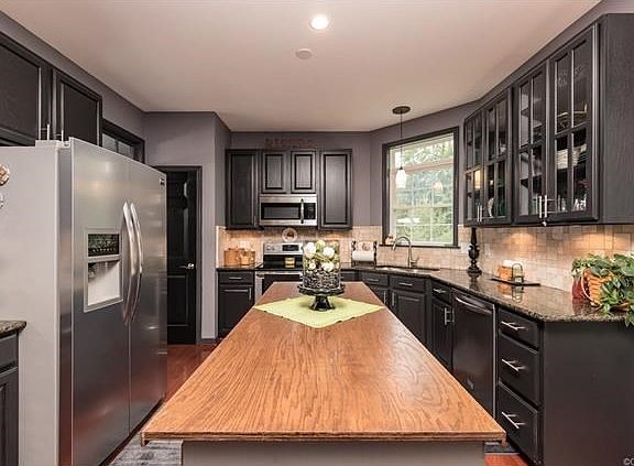 Freshly painted kitchen, island with cabinet storage, stainless steel appliances, undercounter lighting, garbage disposal and pantry. Kitchen appliances convey.