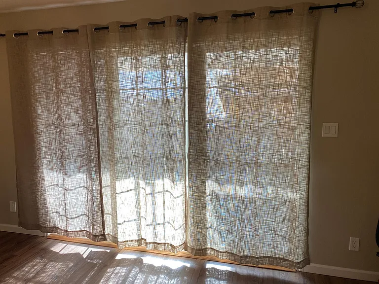 Natural hopsack privacy curtains looking into covered private patio_