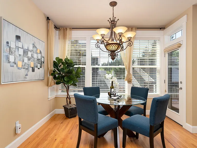 Dining room with wall of windows and deck and backyard access.