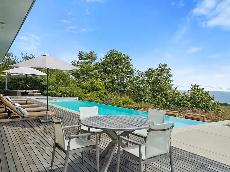 The infinity-edge pool provides unobstructed views of the Pacific Ocean, extending the horizon's beauty.