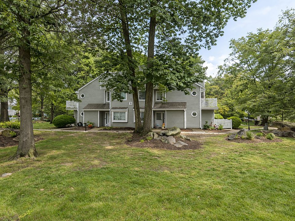 Bright exterior view of the home in a well-maintained, tree-lined community.