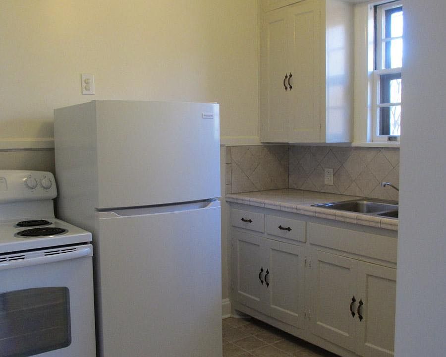 Kitchen view from dining room swinging door. Updated kitchen with new tile counter, flooring. dishwasher. New refrigerator.