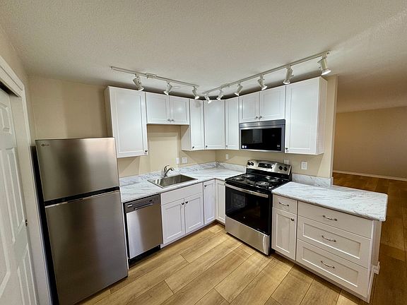 Renovated kitchen with brand new cabinets, appliances, track lighting with LED bulbs, and sink. The multiple track lights prevent any shadows when one is working at the stove, sink, or countertops.