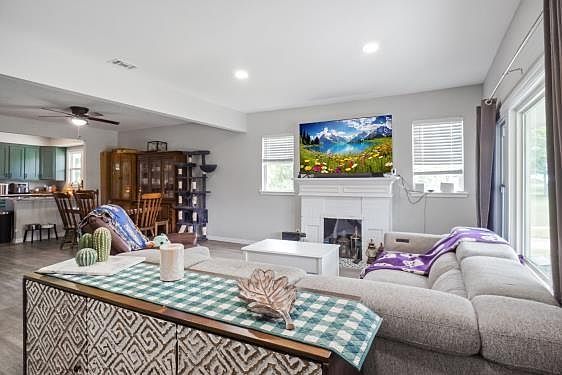 Living area with healthy amount of natural light, ceiling fan, a fireplace, and recessed lighting