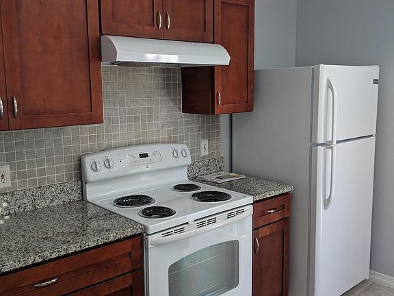 Kitchen with wood cabinets, granite counters and tile back splash appliances one year old