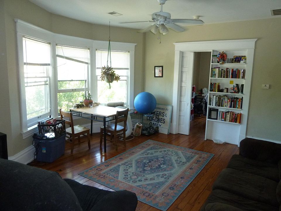 Living room with bay window, built in shelving, and pocket door to BR.