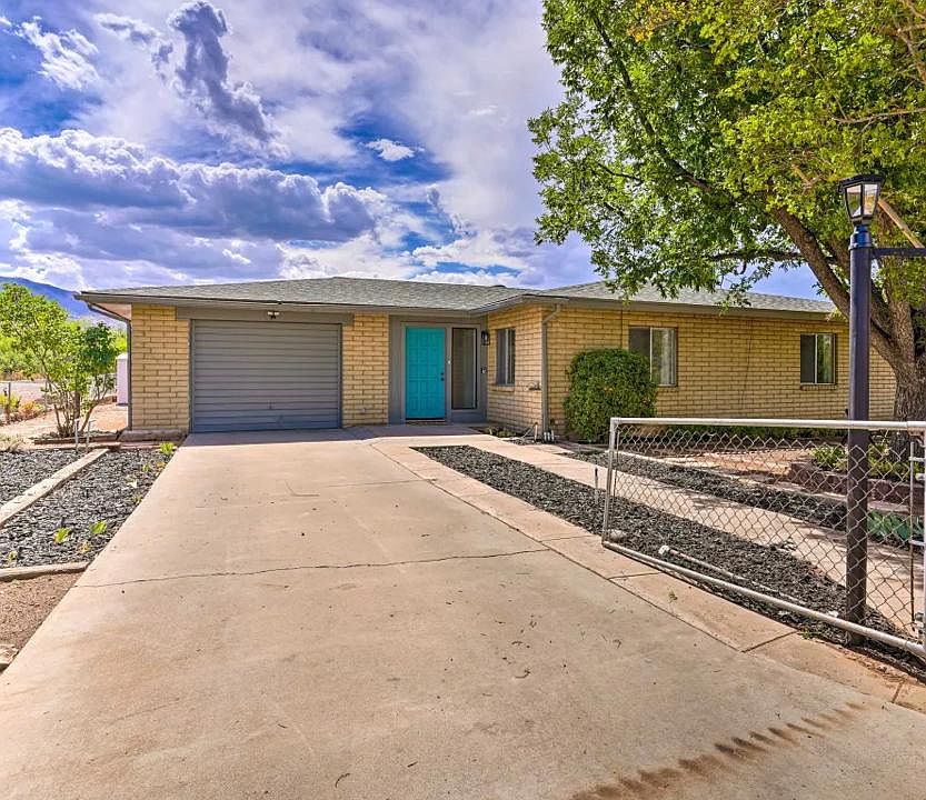 Front of the main house, large drive way with long one car garage and storage room. Large mature trees in the front. Fully fenced.
