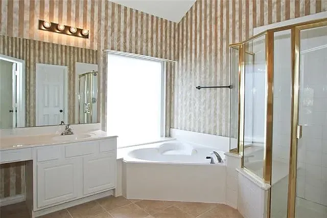Master bath with Jacuzzi and his/her sinks.