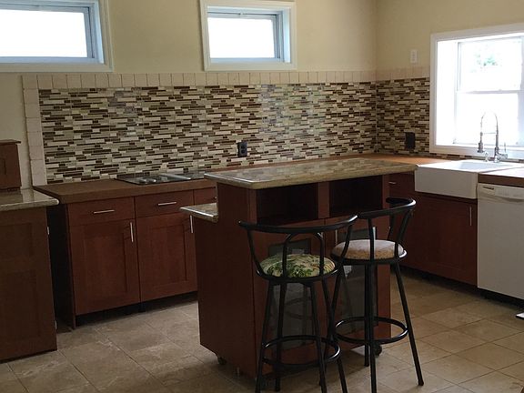 glass tile backsplash with travertine tile border