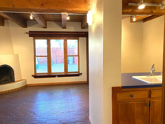 Open living, dining kitchen space. Brick flooring and fireplace.