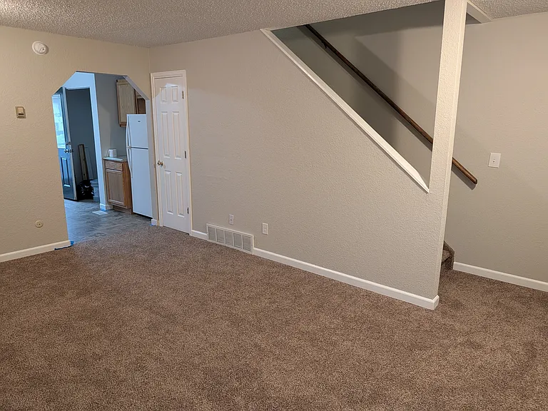 Main floor living room and stairs leading to two bedrooms and full bath.