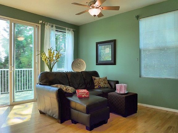 Bright and Open family room with ceiling fan and hardwood flooring.