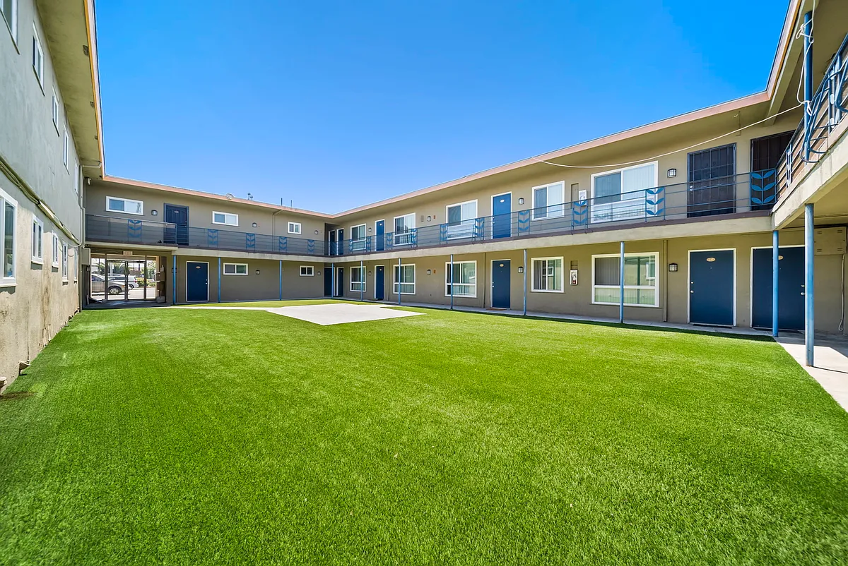 Open courtyard featuring well-maintained green space and convenient access throughout the community. - Courtyard Apartments - Hawthorne