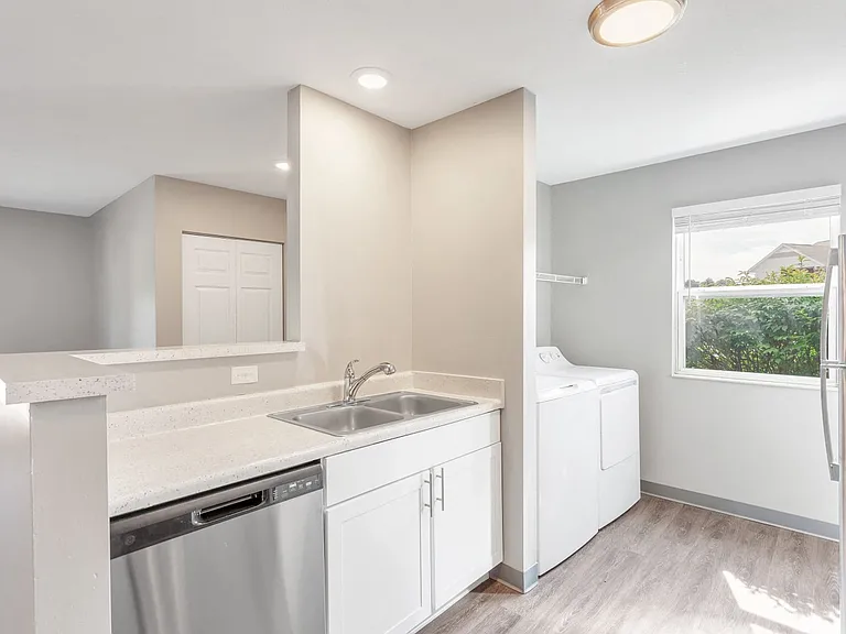 Enjoy modern kitchens featuring a large sink, dishwasher, stainless steel appliances, and bright natural lighting, professionally managed by Highlands Vista Group.
